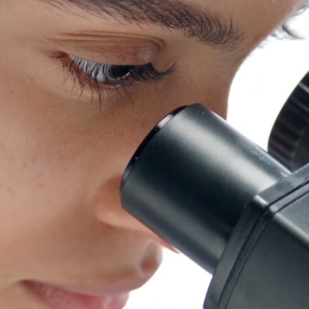 Doctora mirando por microscopio